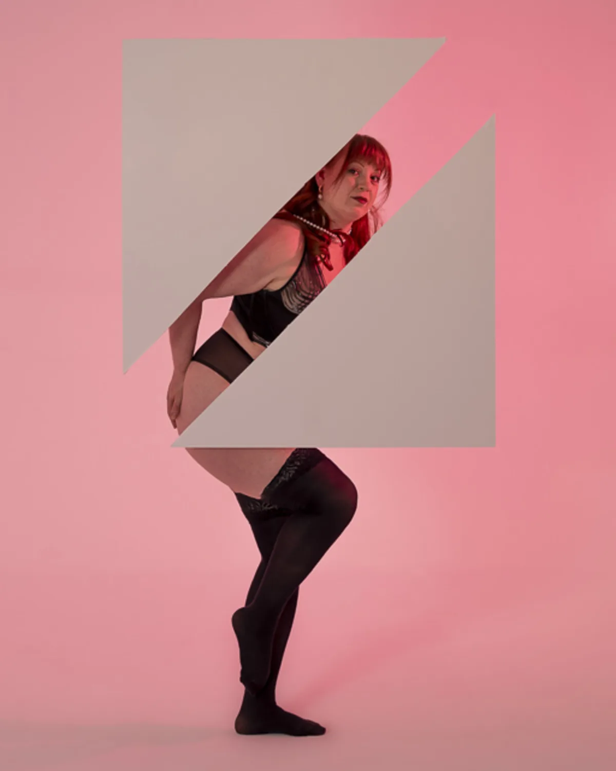 Full-figured woman in black lingerie posing behind abstract geometric
cutouts in a pink-lit studio, with a layered visual effect dividing her body