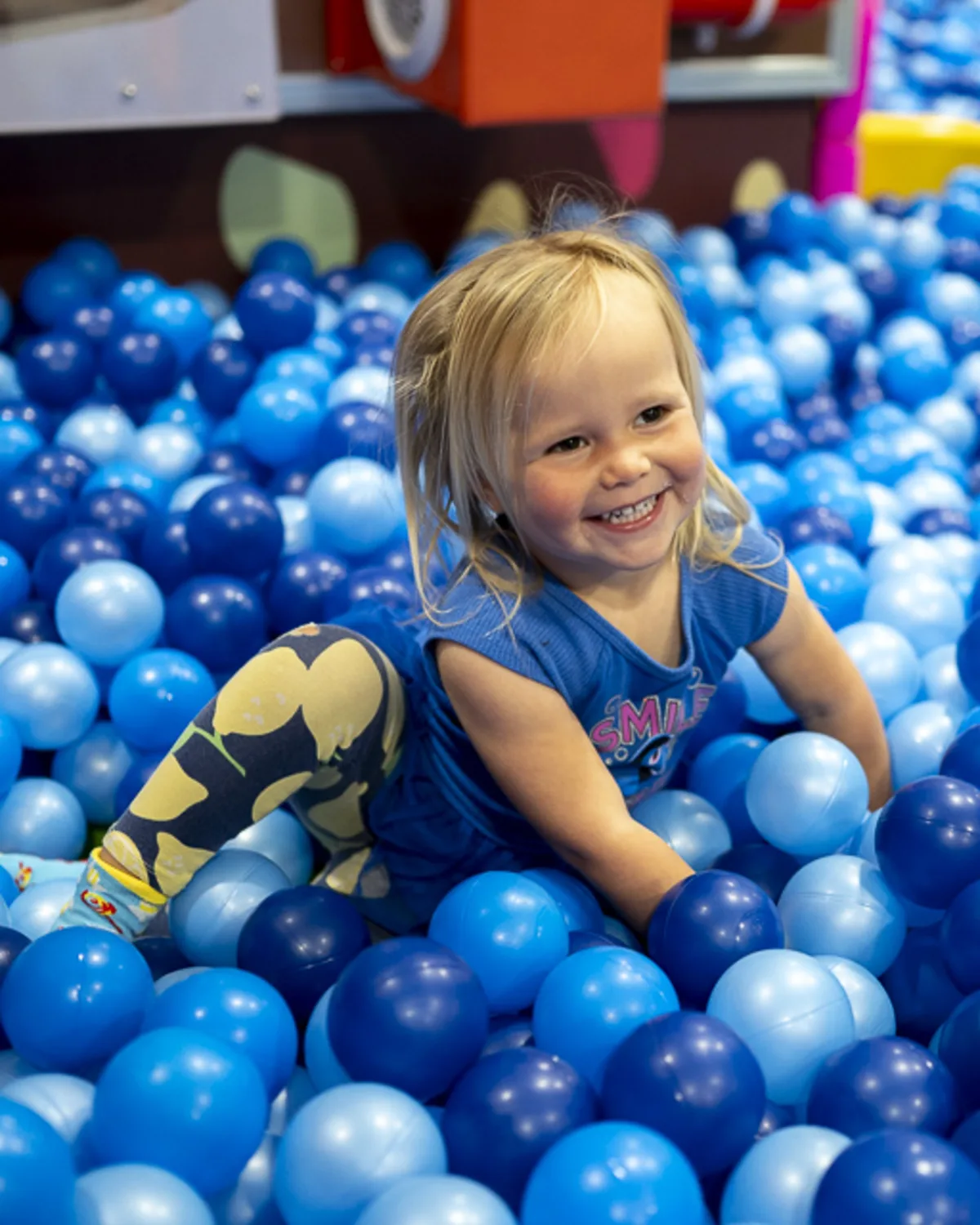 Young child playing in a ball pit at a birthday party in Denver, captured
with colorful candid event photography