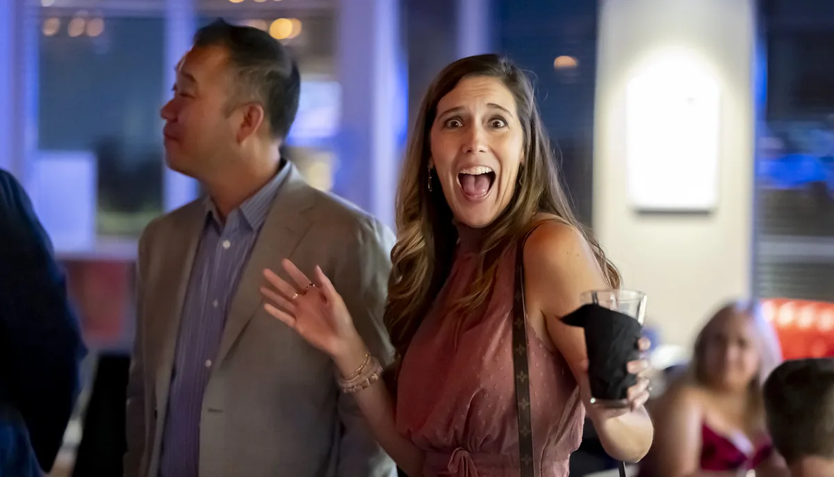 Woman reacting with joy at an engagement party in Denver, candidly captured by
a professional event photographer